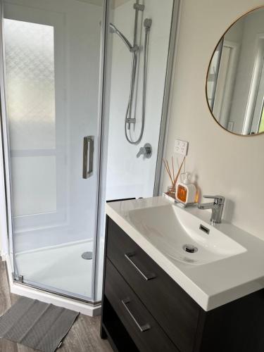 uma casa de banho com um lavatório e um chuveiro em Lakeside cozy studio em Taupo