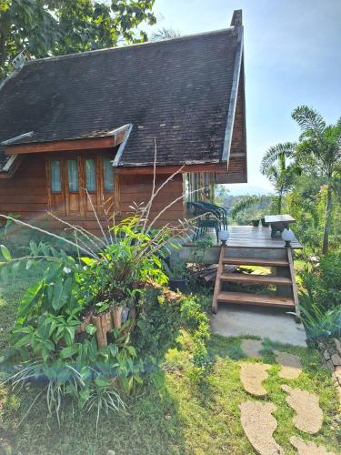 a small wooden house with a wooden bench in front of it at Pai Chao Kha in Pai
