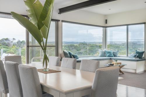 Un comedor con mesa y sillas en The Glasshouse, en Saint Andrews Beach