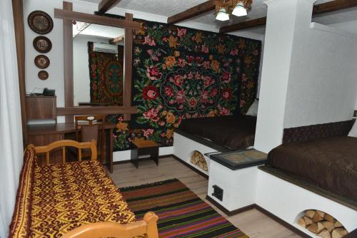 a room with a bed and a table and a couch at Pensiunea Butoias Glodeni in Glodeni