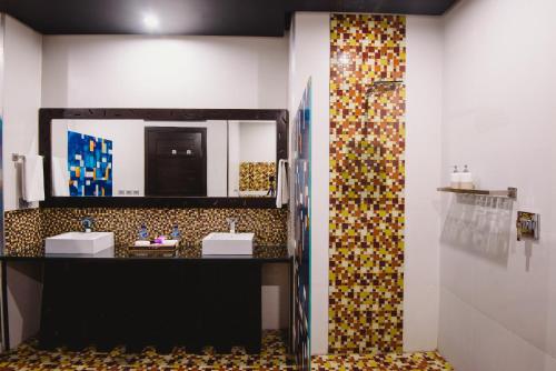 a bathroom with two sinks and a large mirror at L'amore Hotel Seminyak in Seminyak