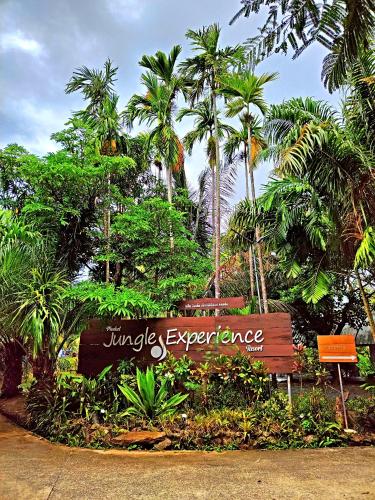 a sign for jungle experience in front of palm trees at Phuket Jungle Experience Resort in Karon Beach