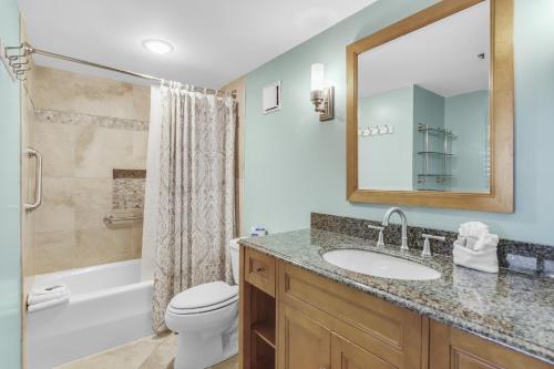a bathroom with a sink and a toilet and a mirror at Magnolia House 507 At Destin Pointe Resort in Destin