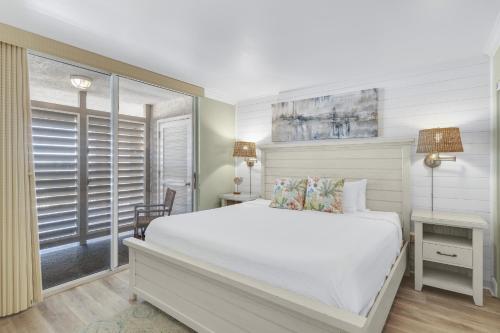 a bedroom with a white bed and a window at Magnolia House 507 At Destin Pointe Resort in Destin