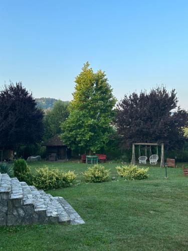 a garden with a stone wall and a gazebo at Vila Rodjak sa sela in Mionica