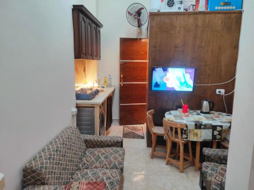 a living room with a table and a kitchen at Youth Palace Hostel هوستل قصر الشباب in Alexandria
