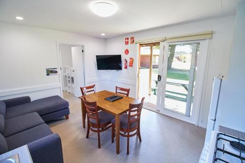 a living room with a table and a couch at Surfside Holiday Park Warrnambool in Warrnambool