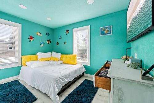 a bedroom with blue walls and a bed with yellow pillows at Above The Sea in St. Petersburg