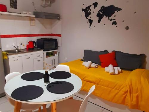 een kamer met 2 bedden, een tafel en een keuken bij APART CENTRO RIOJA, Zona Residencial, Parking privado gratis a 100 mts in Mendoza