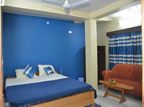 niebieska sypialnia z łóżkiem i kanapą w obiekcie Signature Stay w mieście Port Blair