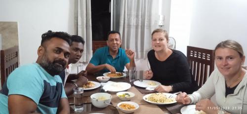 a group of people sitting around a table eating food at Vino Villa Tourists & Local Accommodations - 24 Hrs in Kandy