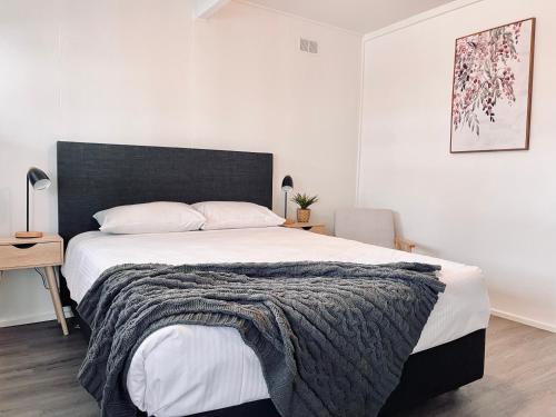a bedroom with a large bed with a black headboard at Motel On Becker in Tintinara