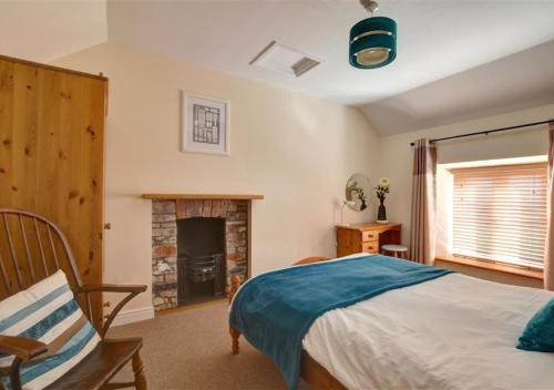 a bedroom with a bed and a fireplace at Glanhafren in Southerndown