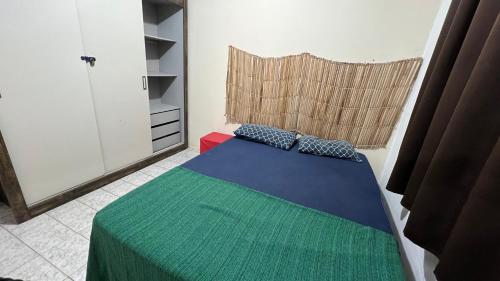 um quarto com uma cama com um cobertor verde e azul em Hospedagem Pedra do Pontal no Rio de Janeiro