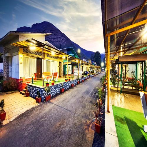 a row of houses with a mountain in the background at Rainforest Resort and Spa, Igatpuri -Nature's Luxury Awaits in Igatpuri