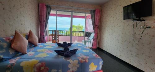 a bedroom with a bed with flowers on it at Puttaraksa kohlarn in Ko Larn