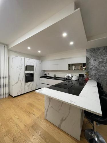 a white kitchen with a large white counter top at Casa di Jo in Empoli