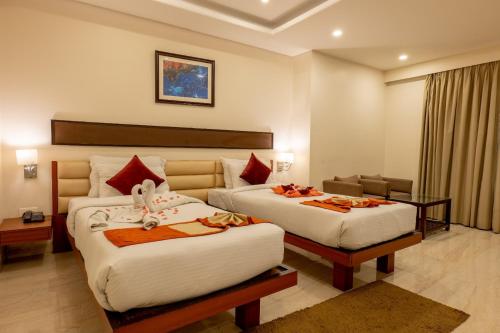 una habitación de hotel con 2 camas en una habitación en Hotel Prism Jorhat, en Jorhāt