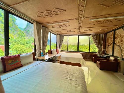 Habitación de hotel con 2 camas y ventana grande. en Tam Coc Eco Field Homes en Ninh Binh