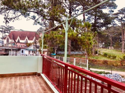 a balcony with a red railing and trees at Whispering Pines Dalat (Thông Thì Thầm ĐL) in Da Lat