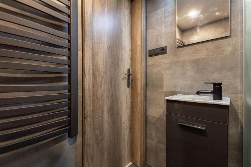 bagno con lavandino e porta in legno di CHARLIE - modern centrally located downtown studio a Bratislava