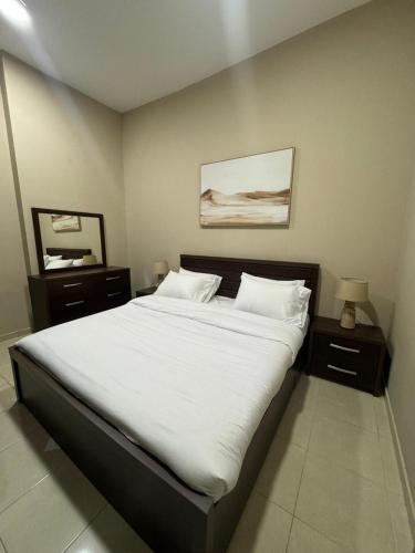 um quarto com uma cama grande e lençóis brancos em Marbella Grand Holiday Homes - Al Nahda 1 no Dubai