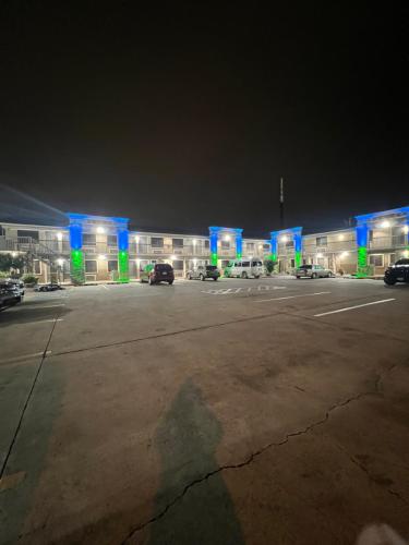a large building with blue lights in a parking lot at Super 8 by Wyndham McAllen-Downtown-Airport-LA Plaza Mall in McAllen