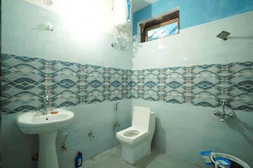 a bathroom with a toilet and a sink at Bloom HomeStay in Almora