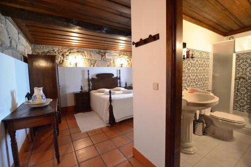 - Baño con dormitorio con cama y lavamanos en Casa de Sta Comba, en Barcelos