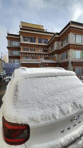 a snow covered car parked in front of a building at HOTEL CHANTSA in Leh