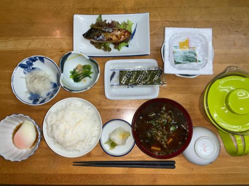 Business Hotel Shizusato Ryokan في أوغاكي: طاولة مليئة بالأطباق وأوعية الطعام
