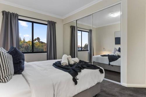 a bedroom with two beds and a large mirror at Luxury Retreat in the Heart of Subiaco in Perth