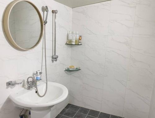 a white bathroom with a sink and a mirror at NK House in Gangneung