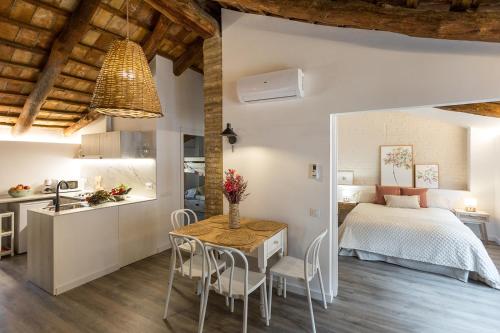 a bedroom and kitchen with a bed and a table and chairs at L’Angorfa de Casa Santiago, casa rural in Tivenys