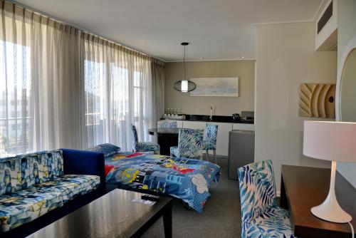 a living room with a couch and a table at Lagoon Beach Hotel & Spa in Cape Town