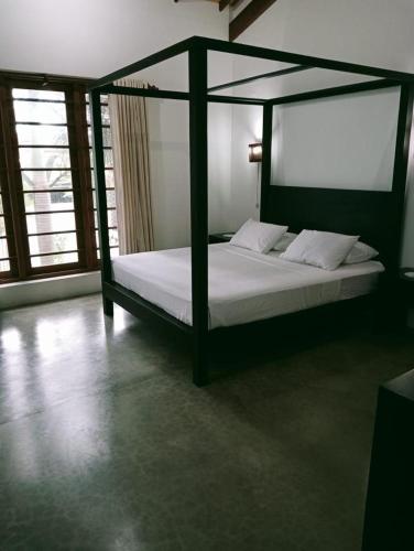 a bedroom with a canopy bed with white sheets at Mount Bliss Home Stay in Mount Lavinia