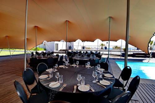 a tent with tables and chairs and a pool at Lagoon Beach Hotel & Spa in Cape Town