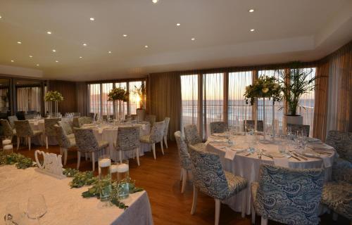 a banquet room with tables and chairs with white tablecloths at Lagoon Beach Hotel & Spa in Cape Town