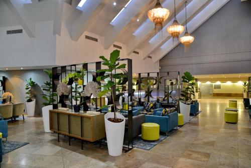 a lobby with a lot of potted plants at Lagoon Beach Hotel & Spa in Cape Town