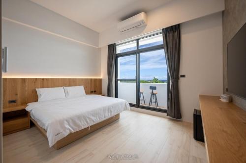 a bedroom with a large bed and a large window at Misu in Xiaoliuqiu