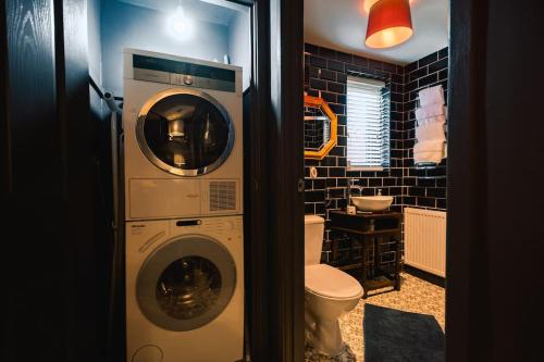 a bathroom with a washing machine and a toilet at Hullidays》Old Town Luxury Cavern in Hull
