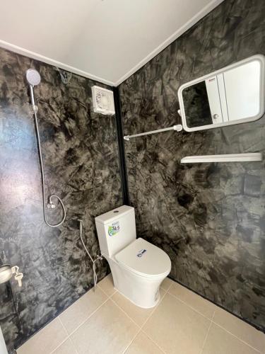 een badkamer met een toilet en een douche bij Piyaporn Guesthouse in Khon Kaen