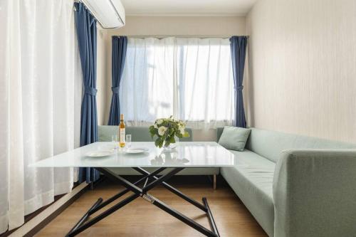 a living room with a white table and a couch at Bright Modern Airbnb in Tokyo's Northern District in Tokyo