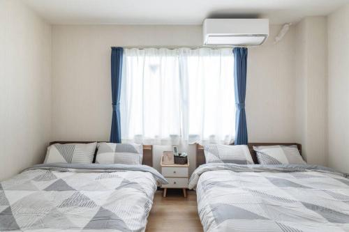 1 dormitorio con 2 camas y ventana en Bright Modern Airbnb in Tokyo's Northern District, en Tokio