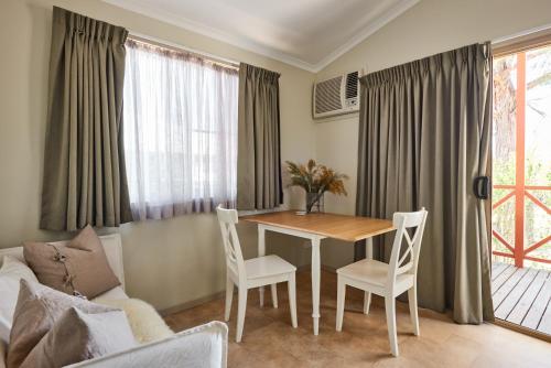 a living room with a table and chairs and a couch at Tenterfield Lodge Caravan Park in Tenterfield