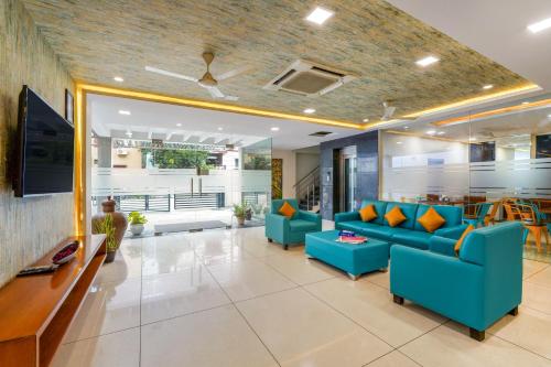 a living room with blue couches and a tv at Westside Hotel Gachibowli in Hyderabad