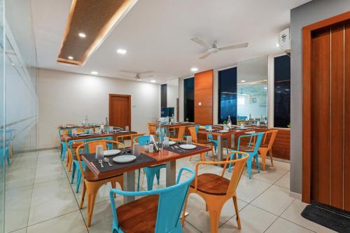 a restaurant with wooden tables and blue chairs at Westside Hotel Gachibowli in Hyderabad