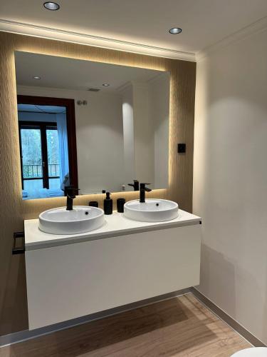 a bathroom with two sinks and a large mirror at Paseo Tenorio, remanso de paz con PISCINA in Ezcaray