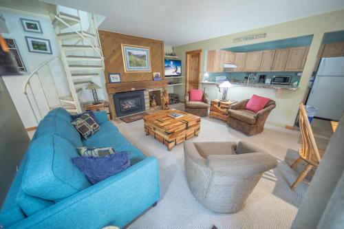 a living room with a blue couch and a fireplace at Flying Dutchman 1192 by SummitCove Lodging in Keystone