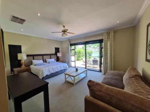 een woonkamer met een bed en een bank bij 2 Park Lane Pecanwood 4 Bedroom in Hartbeespoort
